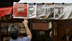 Muž v Aténách si prohlíží vystavené noviny, referující o vítězství Syrizy ve volbách